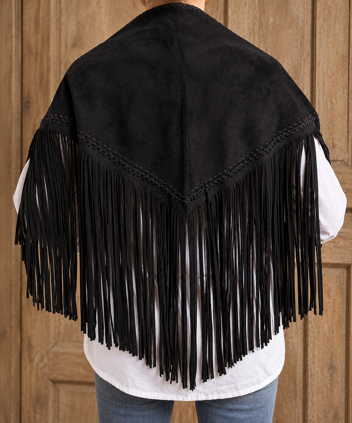 Foulard triangulaire SIOUX en suédine noire porté sur les épaules, longues franges et finitions tressées – BRUT.E